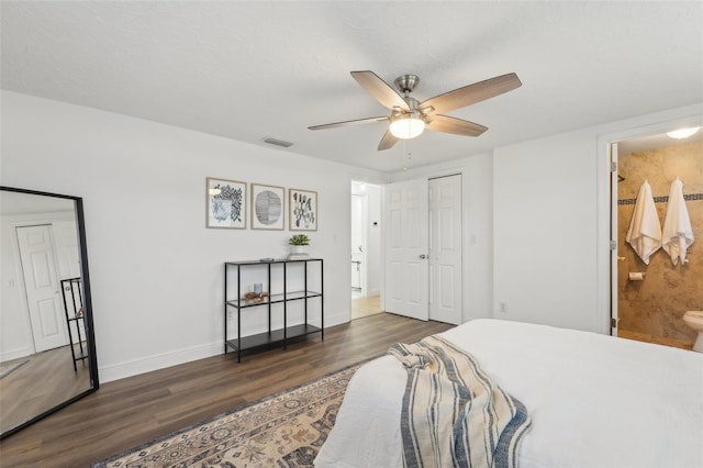 bedroom featuring ceiling fan, dark wood-type flooring, a textured ceiling, and ensuite bathroom