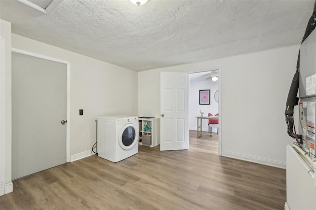 washroom with washer / clothes dryer, light hardwood / wood-style floors, and a textured ceiling