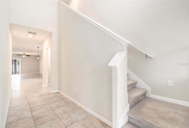 stairway featuring ceiling fan and tile patterned floors