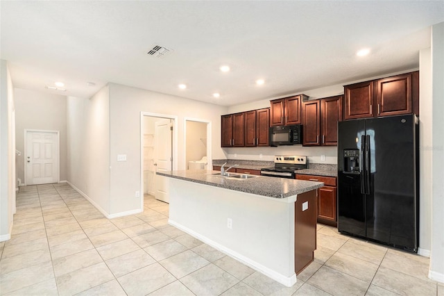 kitchen with light tile patterned flooring, sink, a center island with sink, and black appliances