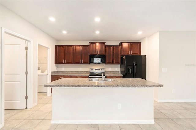 kitchen with black appliances, sink, a kitchen island with sink, separate washer and dryer, and light tile patterned floors