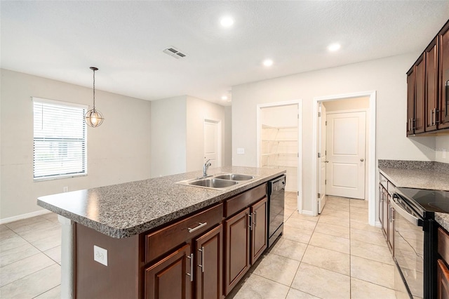 kitchen with light tile patterned floors, a kitchen island with sink, pendant lighting, black appliances, and sink