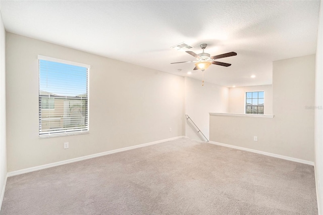 carpeted spare room featuring ceiling fan