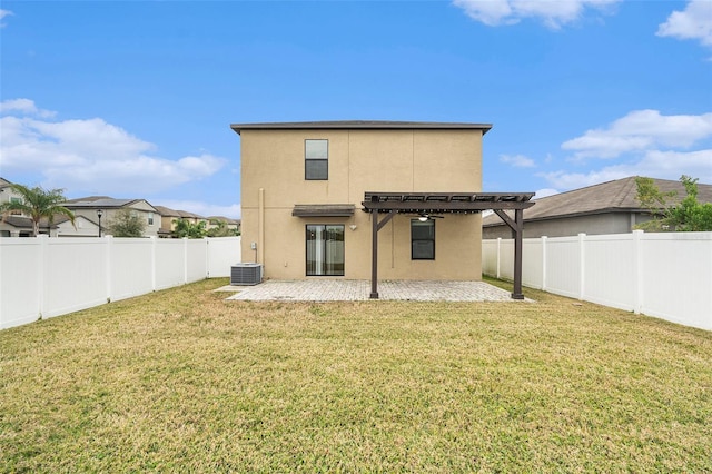 back of property featuring a pergola, a patio area, central AC, and a yard