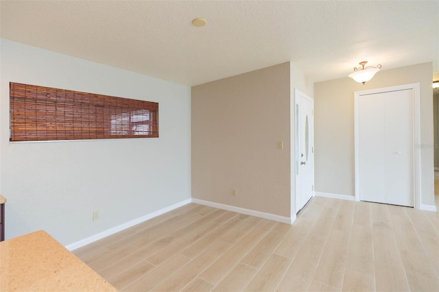 spare room featuring a textured ceiling and light wood-type flooring