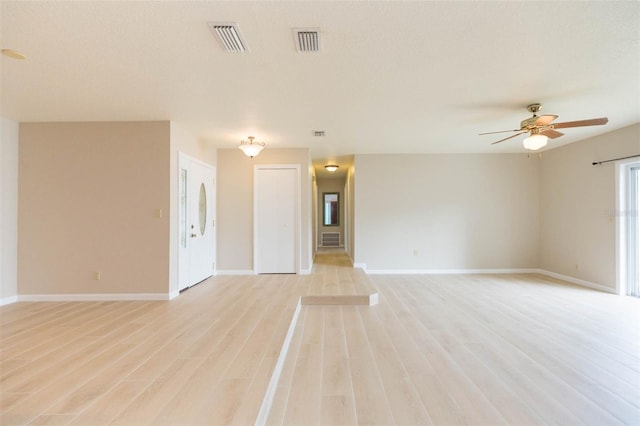 unfurnished living room with ceiling fan, a textured ceiling, and light hardwood / wood-style flooring