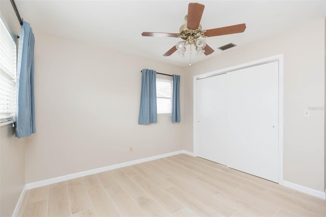 unfurnished bedroom featuring ceiling fan, a closet, and light hardwood / wood-style flooring