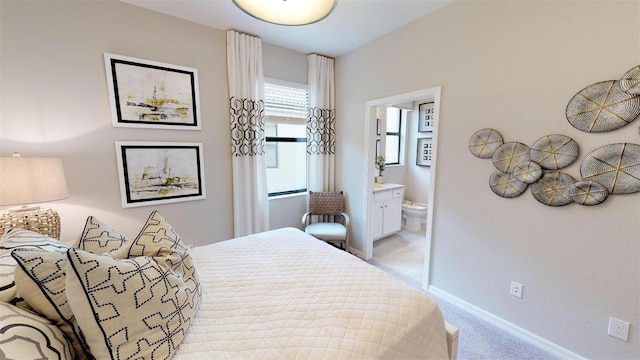 bedroom featuring connected bathroom and light carpet