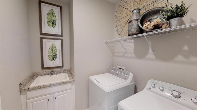 laundry area featuring sink, cabinets, and independent washer and dryer