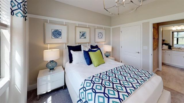 bedroom with an inviting chandelier, carpet floors, and ensuite bathroom