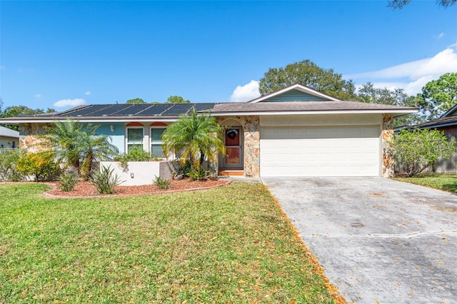 single story home with a garage, a front yard, and solar panels