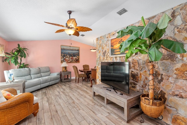 living room featuring a textured ceiling, ceiling fan, lofted ceiling, and light hardwood / wood-style floors