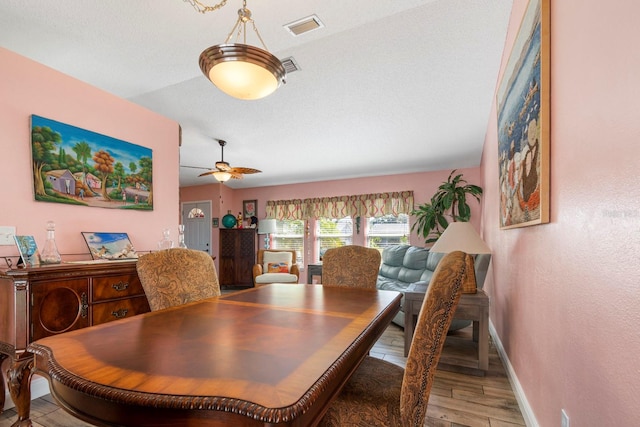 dining area featuring ceiling fan, light hardwood / wood-style flooring, and vaulted ceiling