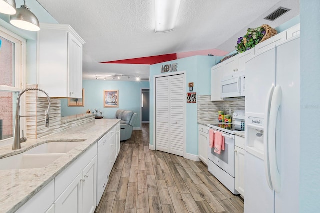 kitchen with white cabinetry, sink, decorative backsplash, and white appliances