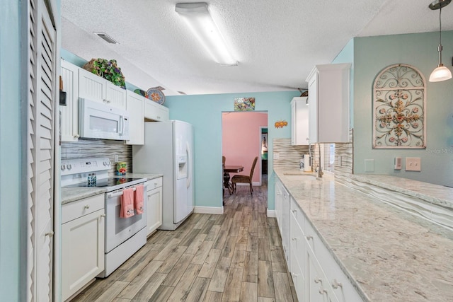 kitchen with pendant lighting, backsplash, white appliances, and white cabinets