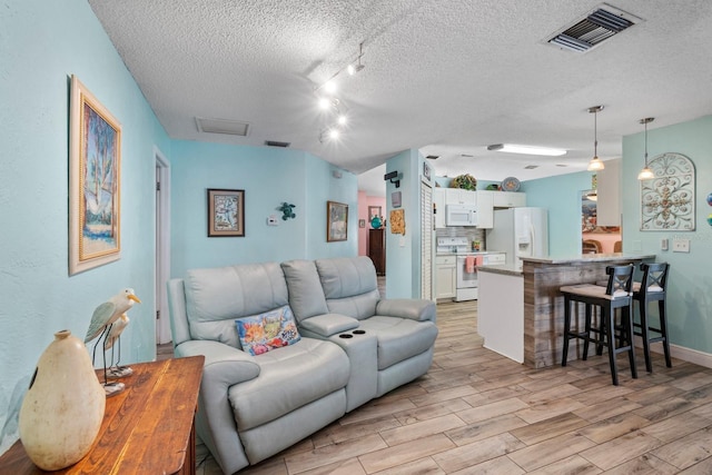 living room with a textured ceiling and rail lighting