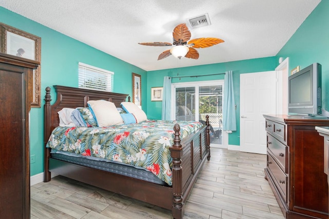 bedroom with ceiling fan and a textured ceiling