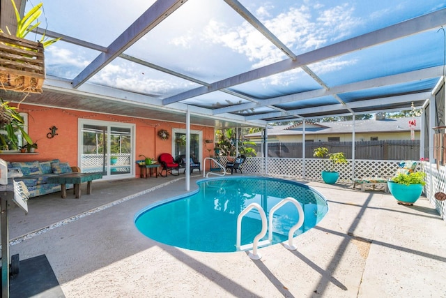 view of swimming pool with a patio area and a lanai