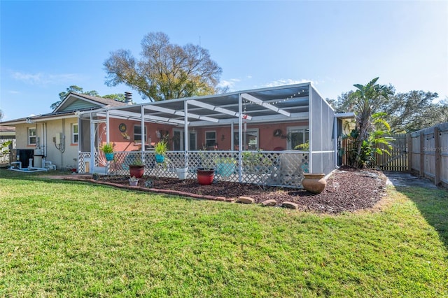 rear view of property with a lanai and a yard