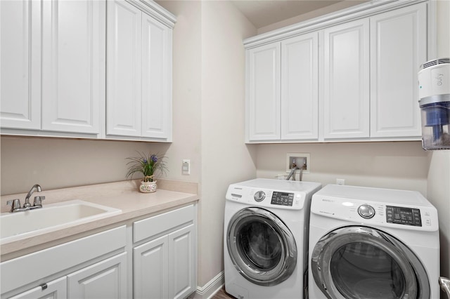 washroom with cabinets, separate washer and dryer, and sink