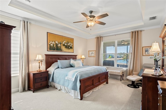 bedroom featuring light colored carpet and a tray ceiling