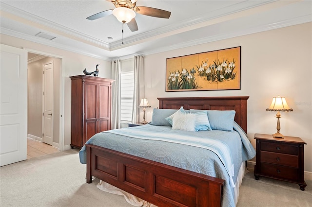 carpeted bedroom featuring a tray ceiling, ornamental molding, and ceiling fan