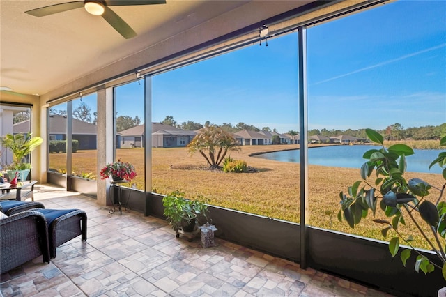 sunroom / solarium with a water view and ceiling fan