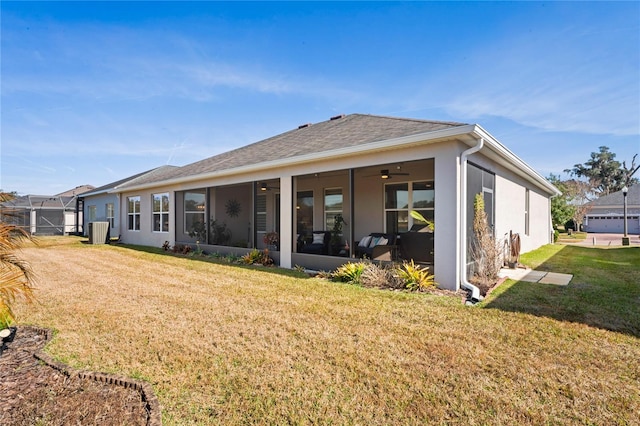 rear view of house featuring cooling unit, ceiling fan, and a lawn