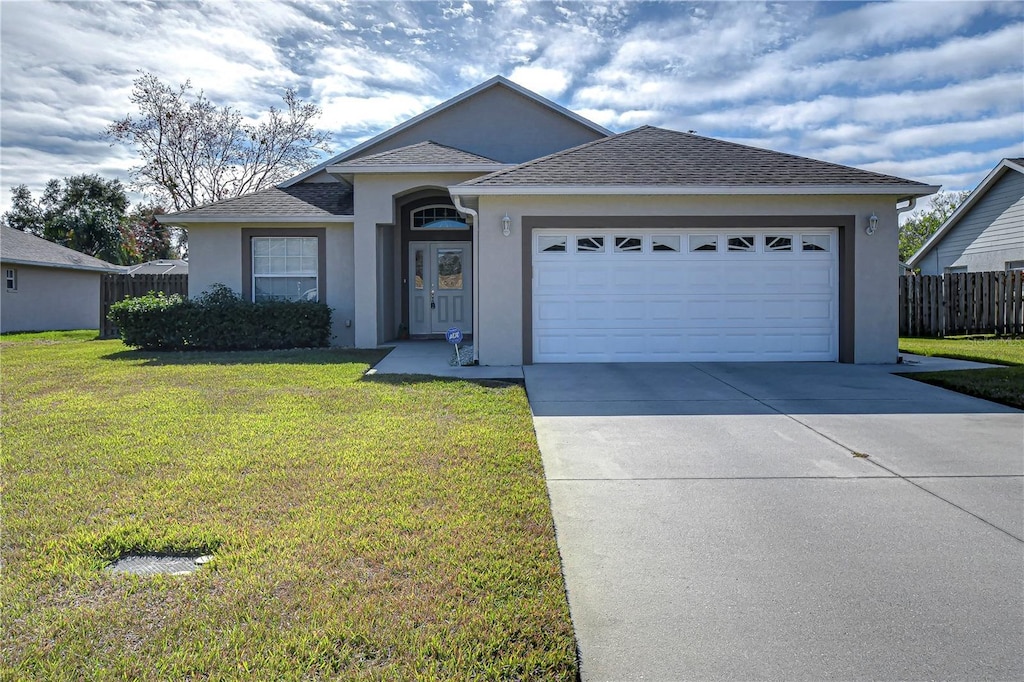 ranch-style house featuring a front lawn and a garage