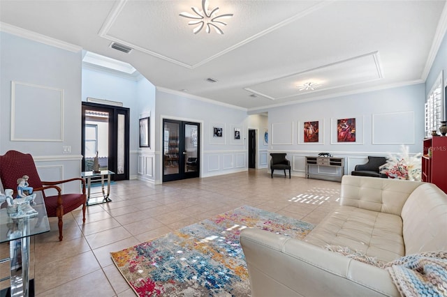 tiled living room with ornamental molding and french doors