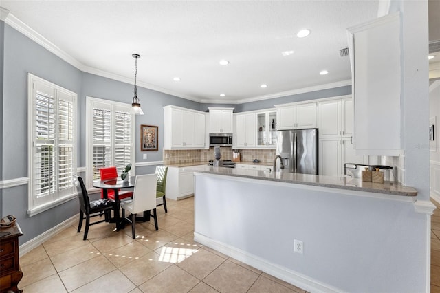 kitchen with light tile patterned flooring, white cabinetry, hanging light fixtures, stainless steel appliances, and light stone countertops