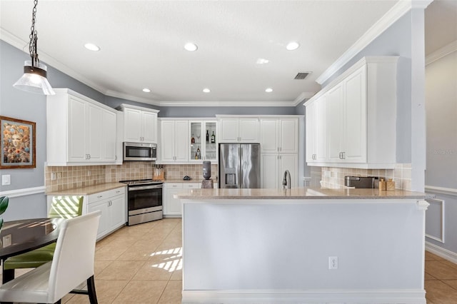 kitchen featuring pendant lighting, white cabinetry, light tile patterned floors, kitchen peninsula, and stainless steel appliances