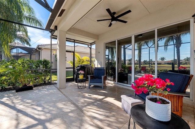 view of patio / terrace featuring ceiling fan, area for grilling, and glass enclosure