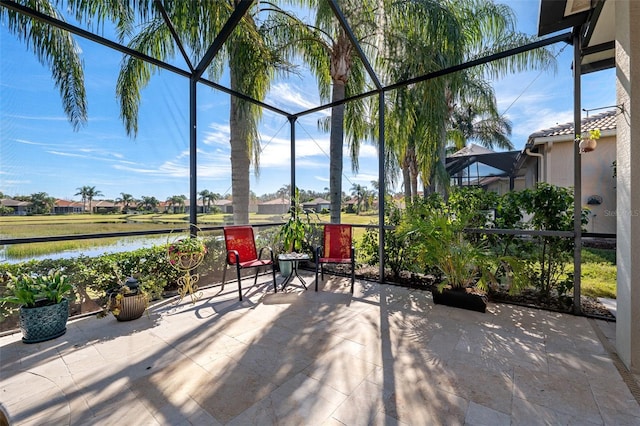 sunroom featuring a water view