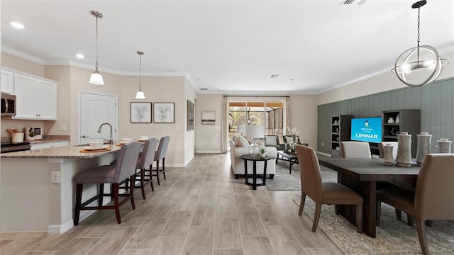 dining space with sink and ornamental molding