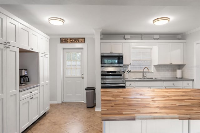 kitchen featuring sink, white cabinetry, stainless steel appliances, and wood counters