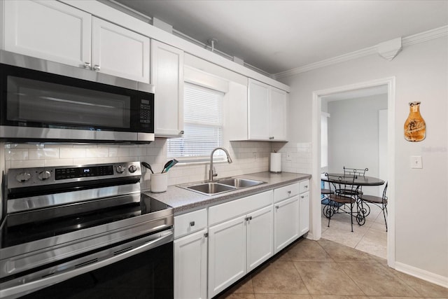 kitchen with light tile patterned flooring, appliances with stainless steel finishes, white cabinetry, and sink