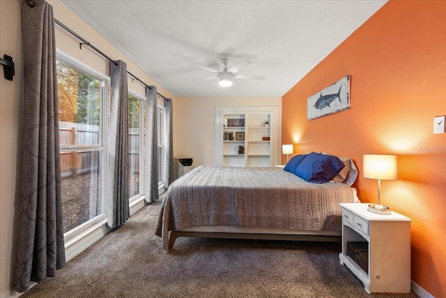 bedroom with ceiling fan and dark carpet