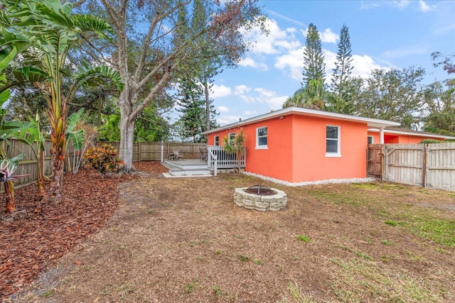 view of yard featuring a deck and a fire pit