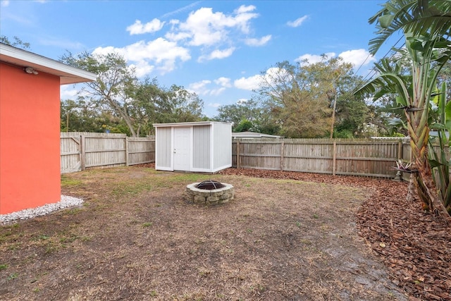 view of yard with a storage shed and a fire pit