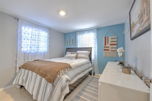 bedroom featuring light tile patterned flooring and baseboards