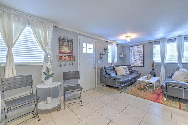 living room featuring light tile patterned floors, baseboards, and crown molding