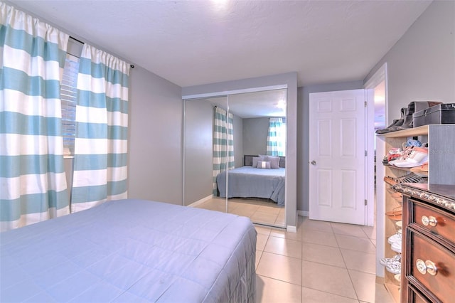 bedroom with a closet, baseboards, and light tile patterned floors