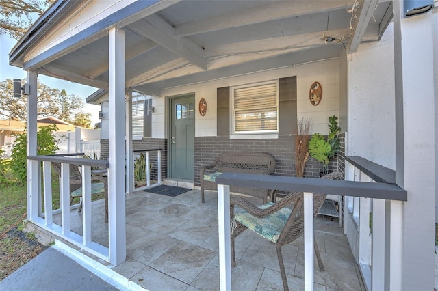 entrance to property with covered porch and brick siding