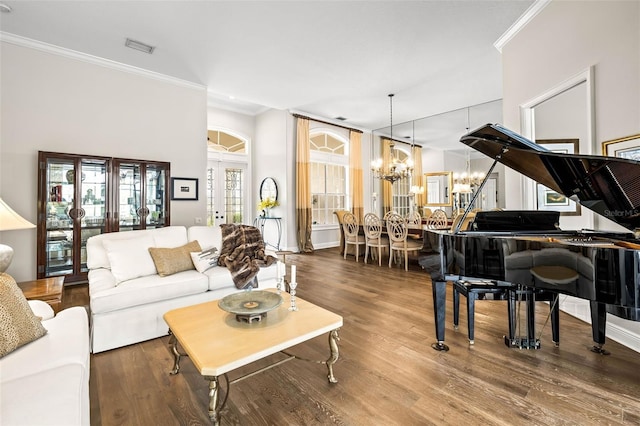 living room with an inviting chandelier, hardwood / wood-style flooring, and crown molding