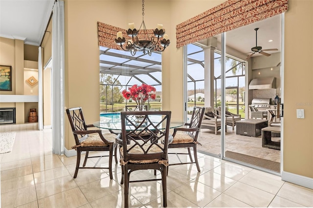 dining space with crown molding, ceiling fan with notable chandelier, a towering ceiling, and light tile patterned floors