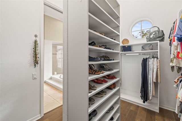 walk in closet with dark wood-type flooring