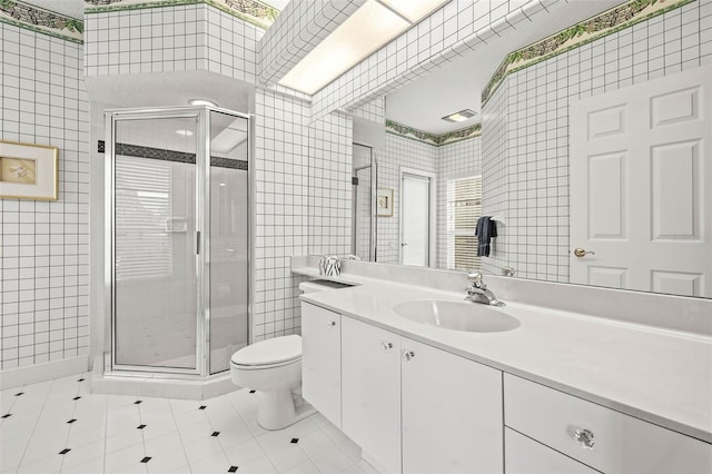 bathroom featuring walk in shower, tile patterned floors, toilet, tile walls, and vanity