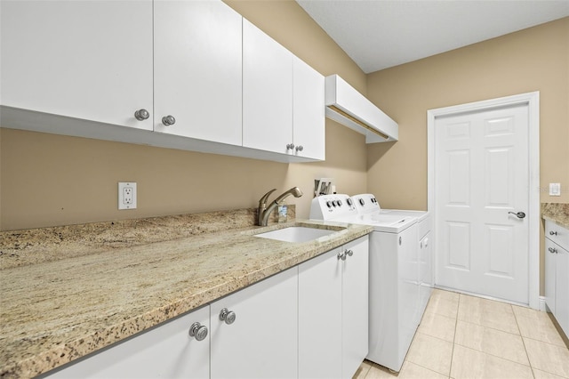 washroom with cabinets, washing machine and dryer, sink, and light tile patterned flooring