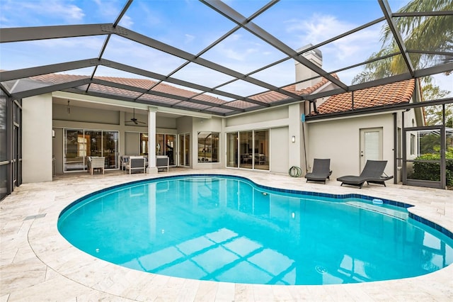 view of swimming pool featuring ceiling fan, a lanai, and a patio